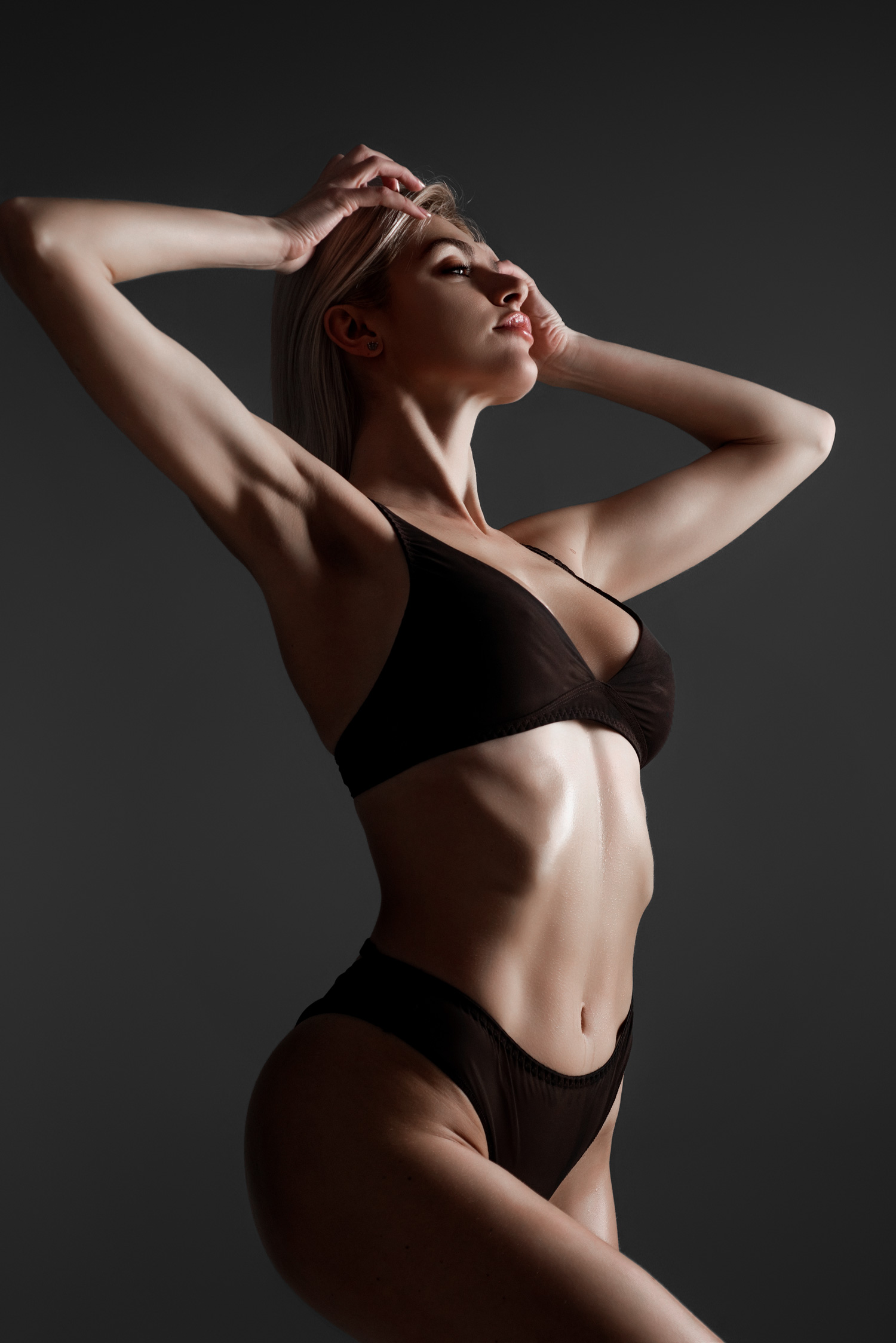 Woman with sculpted figure posing in studio light