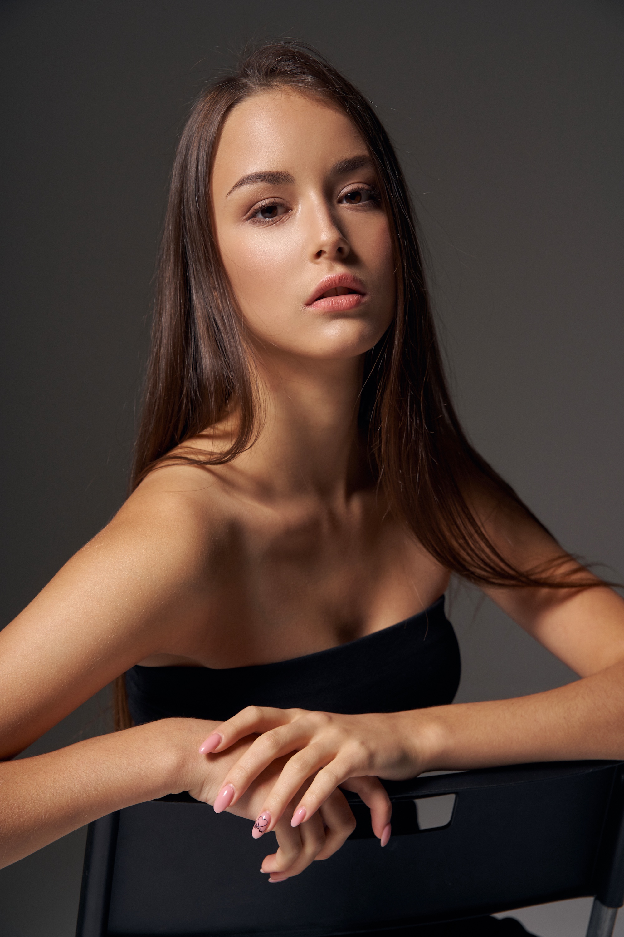 Woman with smooth clear skin resting her arms on a chair