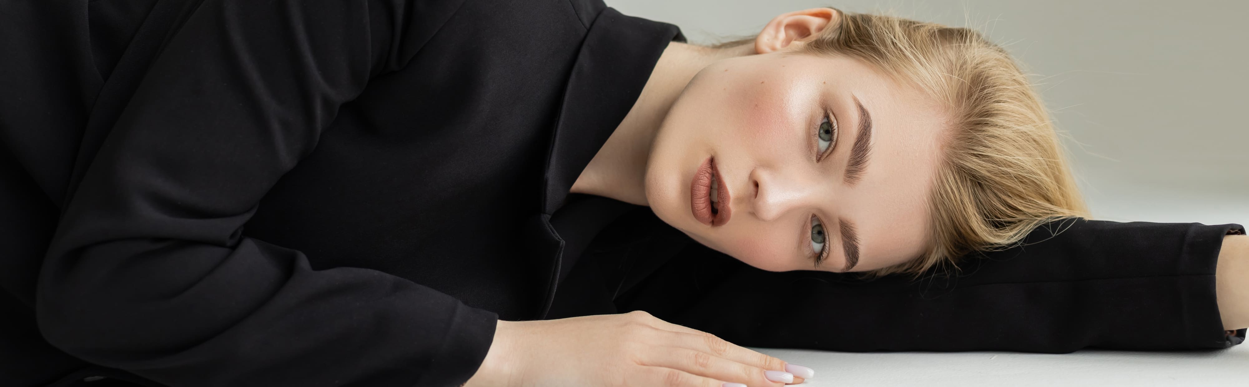Woman with flawless skin resting her head on a table
